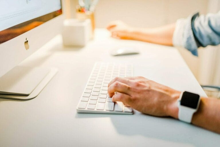Person at a desk working on an iMac computer