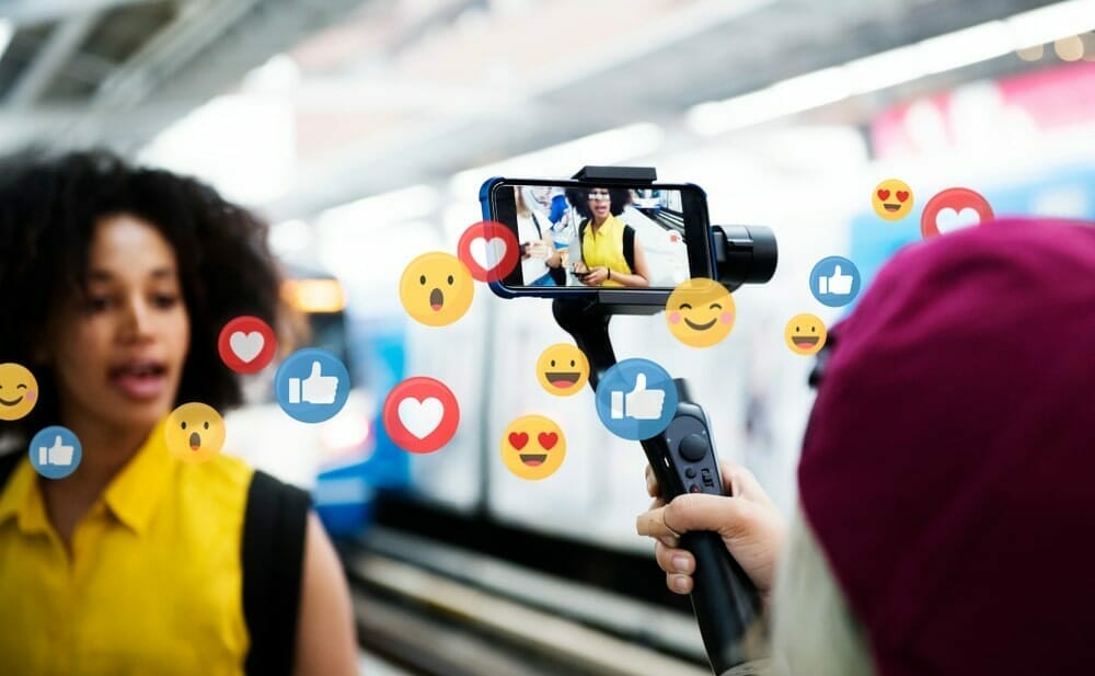 Woman being videotaped by cell phone camera on a stick