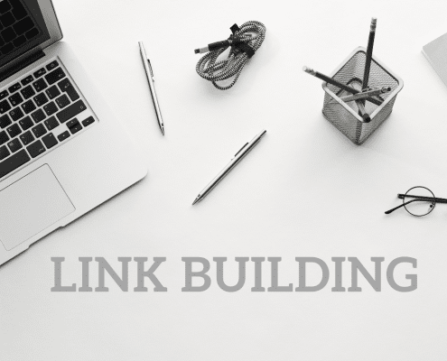 Laptop, pens, pencils, watch and eyeglasses with the words Link Building