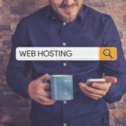 guy holding phone searching for web hosting