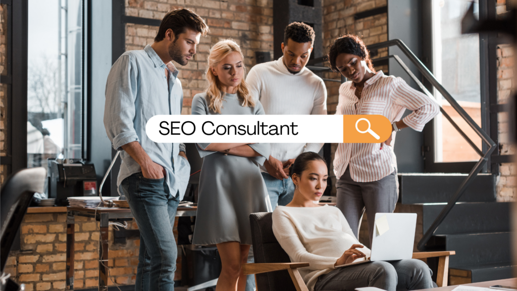 Woman sitting with a laptop with 4 people looking over her shoulder