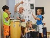 Anthony Hutchcroft playing hand drums with children