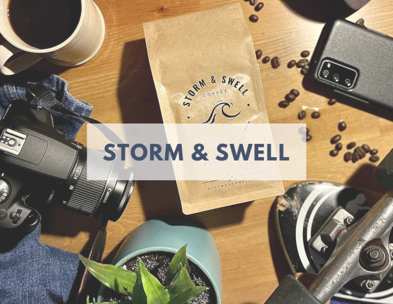 Storm & Swell brand name over an image of a bag of their coffee surrounded by a camera, smartphone, coffee, etc.