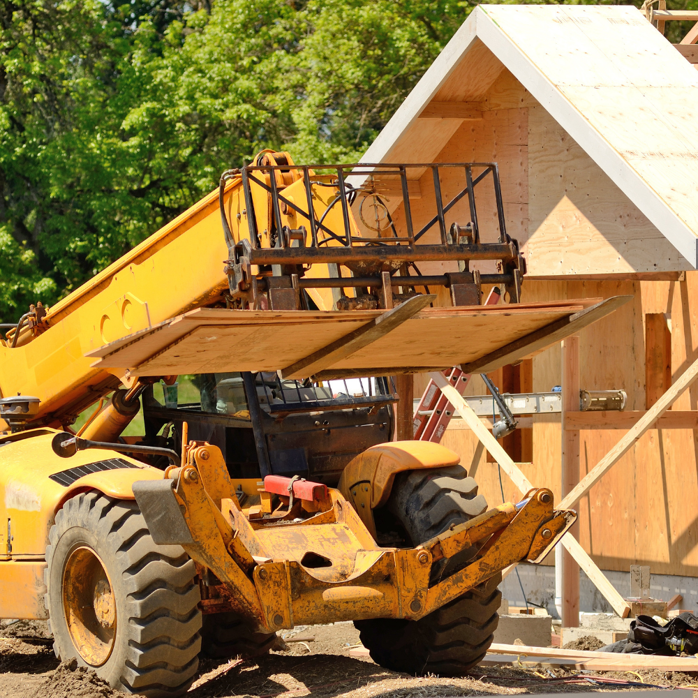 Photo of a forklift in front of a new home construction.