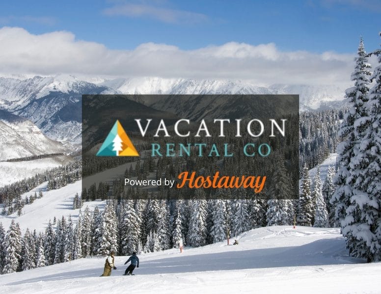 A snow-covered mountain landscape with skiers in the foreground. Tall pine trees frame the scene. Overlay text reads "Vacation Rental Co - Powered by Hostaway.