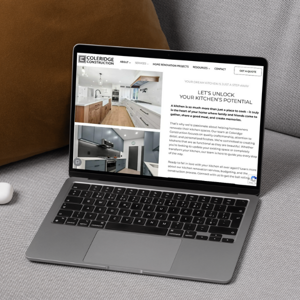 A laptop displaying a kitchen renovation website is on a couch. The website headline reads, "Let's Unlock Your Kitchen's Potential." The screen shows images of a modern kitchen and text about kitchen remodeling services.